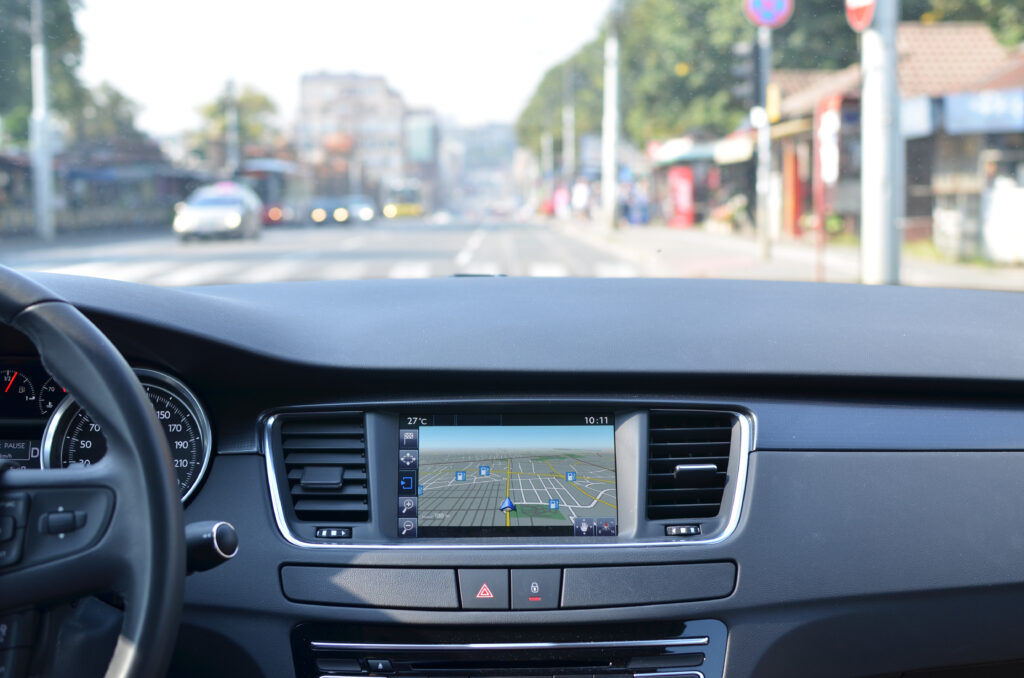View from inside a car on a part of dashboard looking in to a blurred road